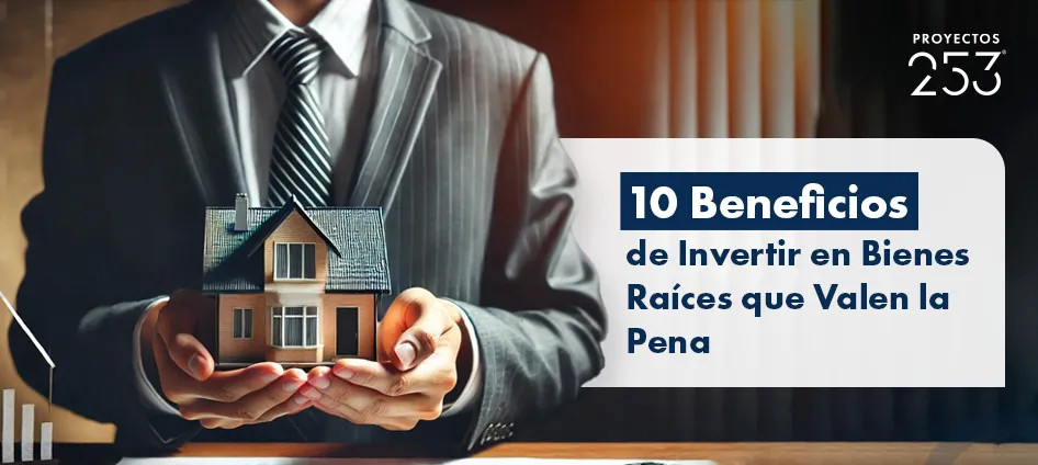 Hombre de negocios en traje sosteniendo una casa en miniatura entre sus manos como portada del artículo 10 Beneficios de Invertir en Bienes Raíces que Valen la Pena